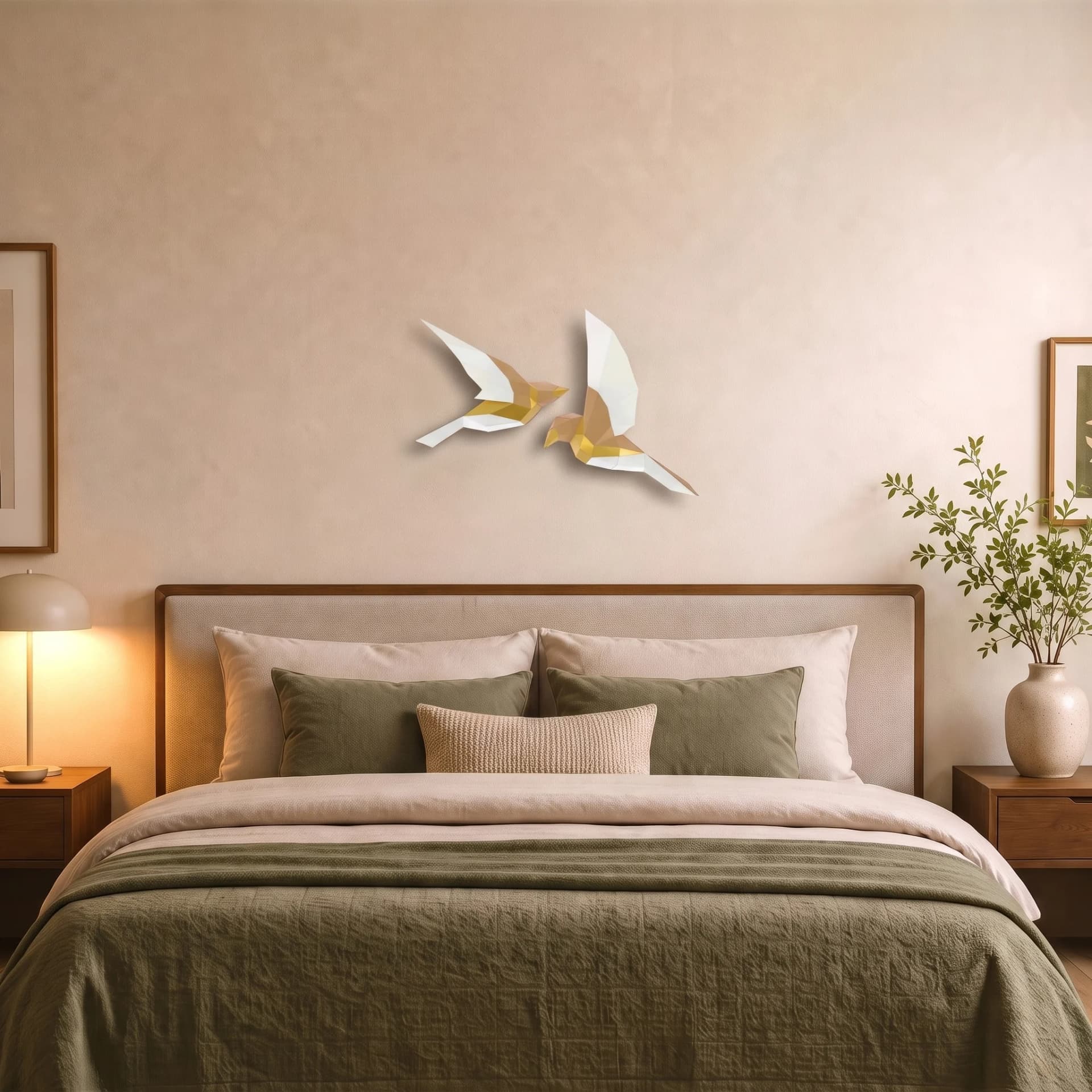 Décoration origami en papier de deux oiseaux beige et dorés accrochés au-dessus d'un lit