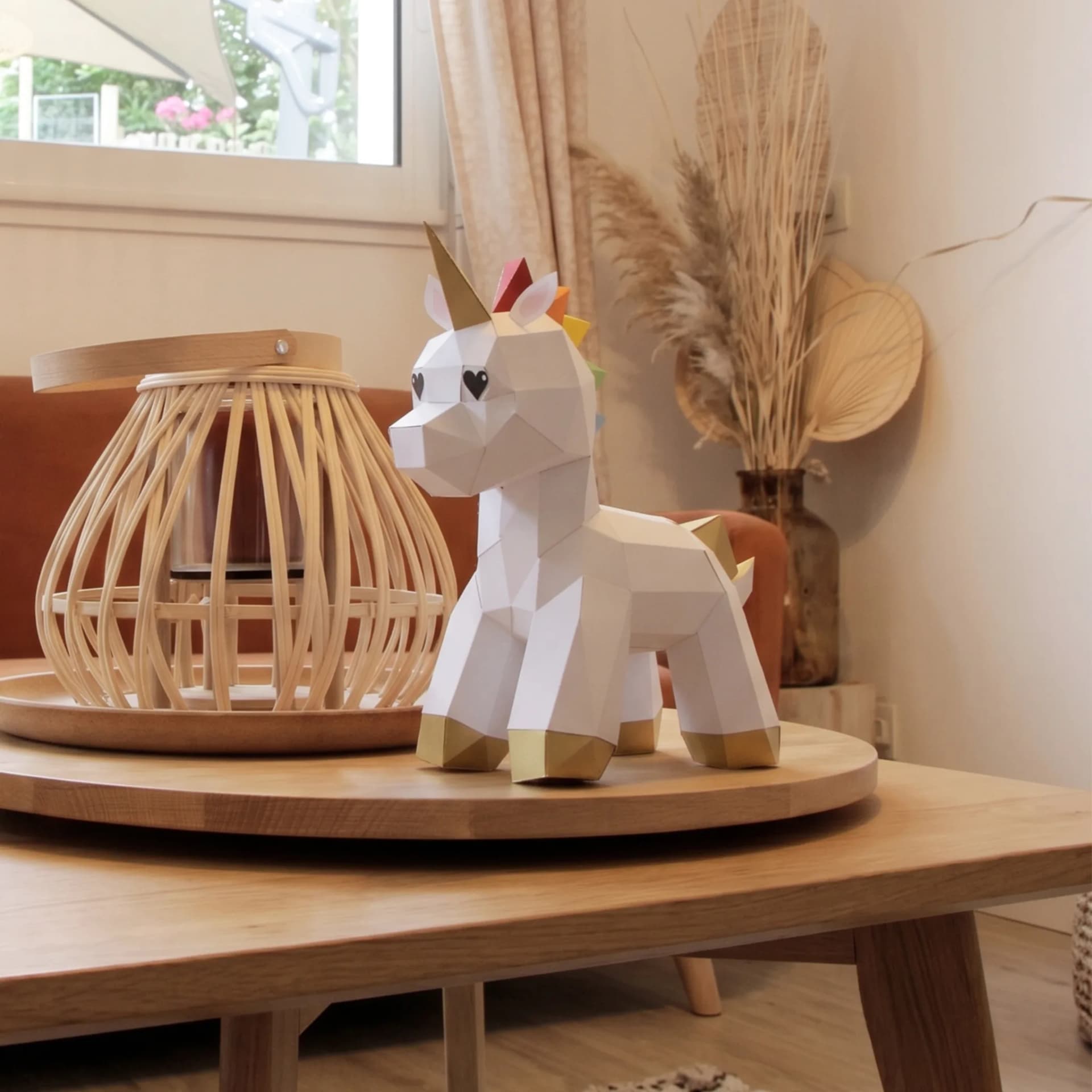 Décoration origami 3D en papier de bébé licorne, posé sur une table de salon