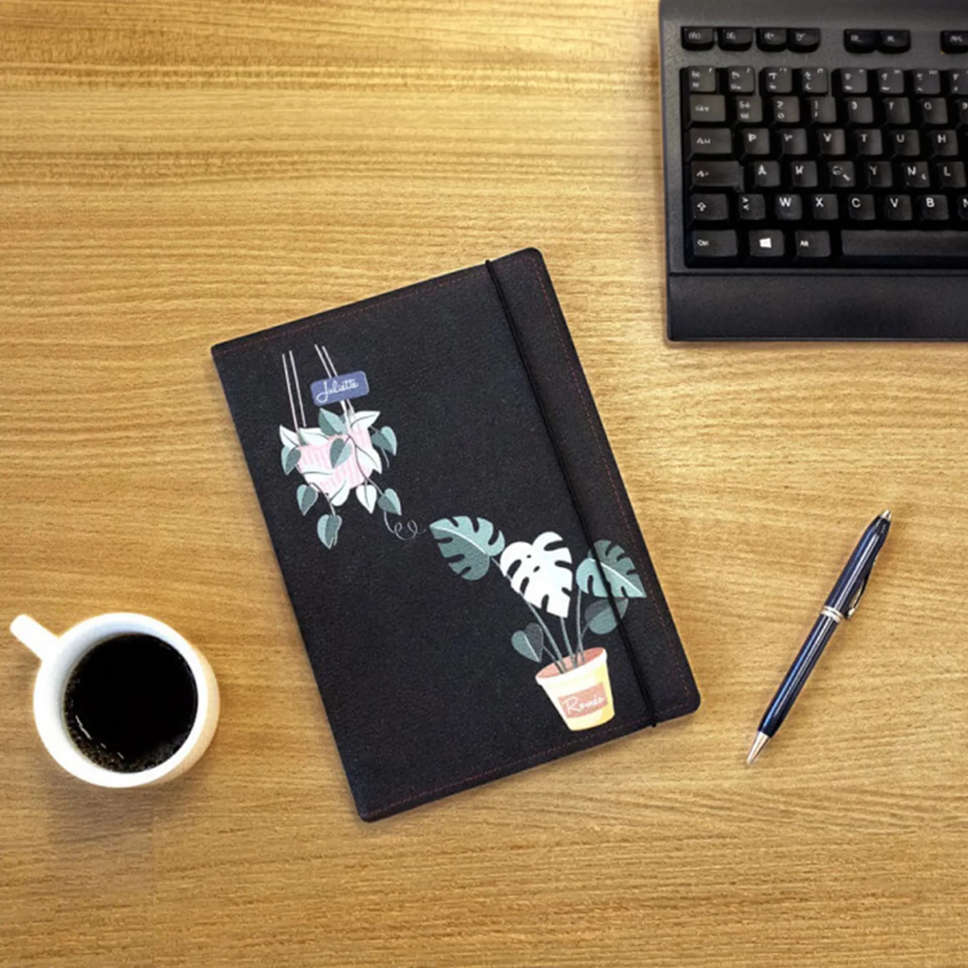 Papeterie couverture en cuir de carnet personnalisé plantes d'interieur posé sur un bureau