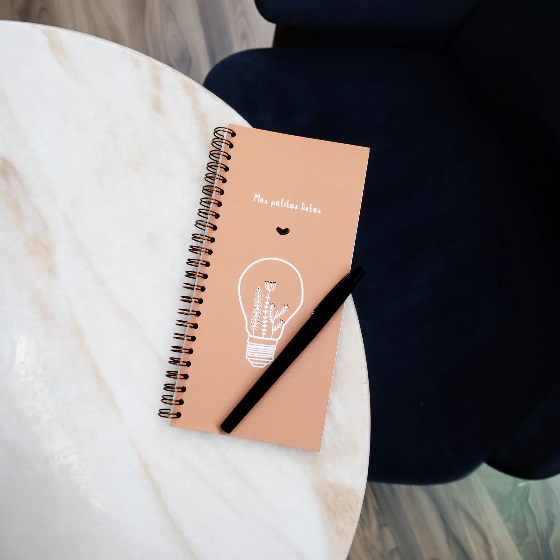 Papeterie couverture de carnet mes petites listes posé sur une table en marbre avec un stylo