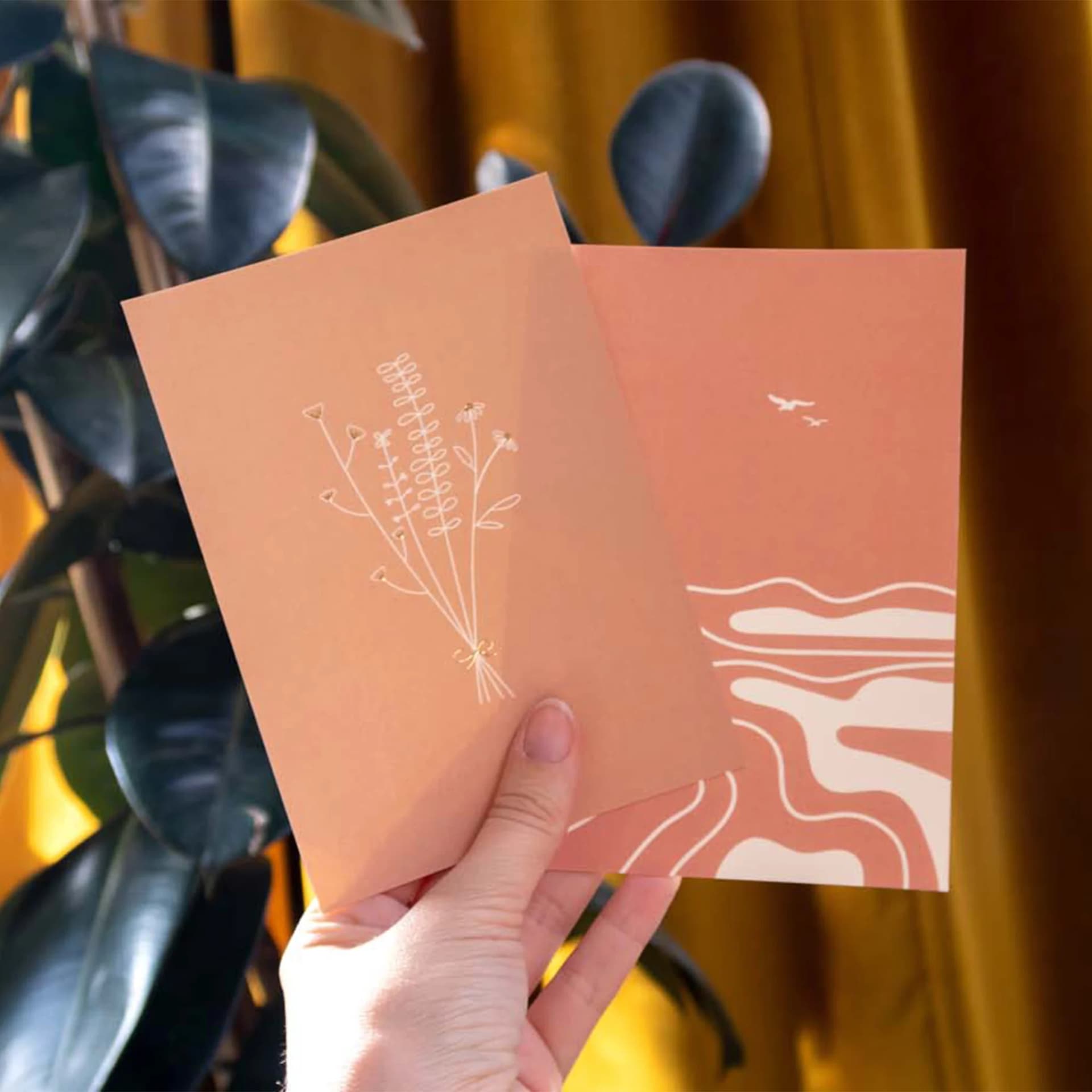 Papeterie cartes postales minimalistes Fleur et Mer tenue dans une main
