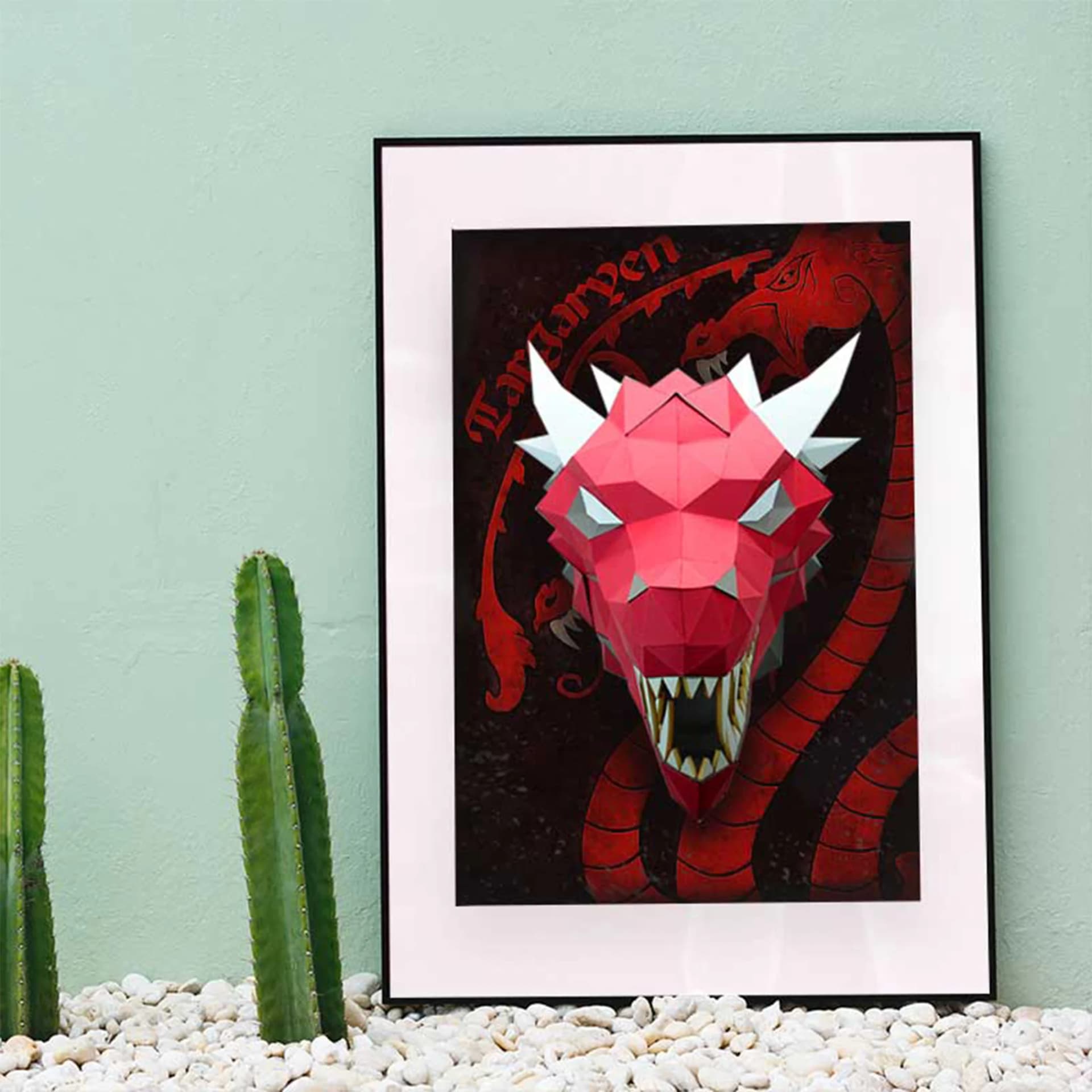 Décoration origami dragon en papier Rouge & gris sur un cadre posé sur des cailloux près de cactus
