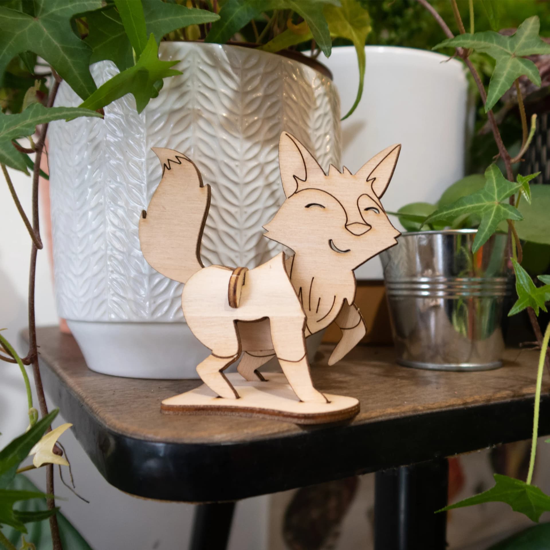 Décoration les p'tits bidules en bois Renard posé devant des plantes