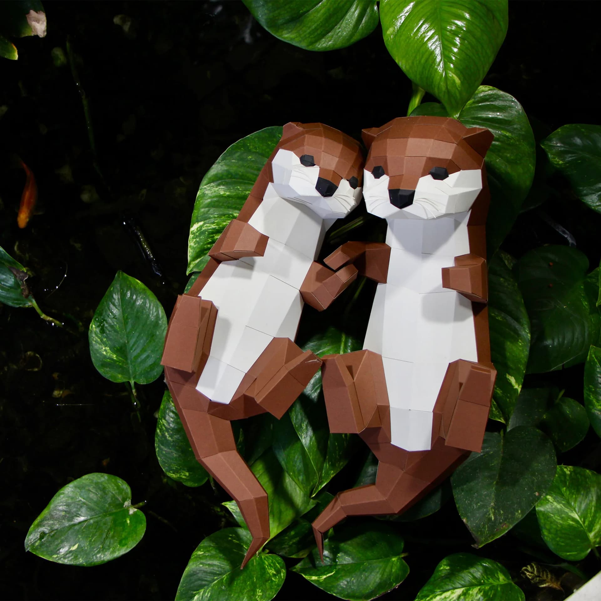 Décoration origami loutres Duo posées sur des feuilles au dessus de l'eau
