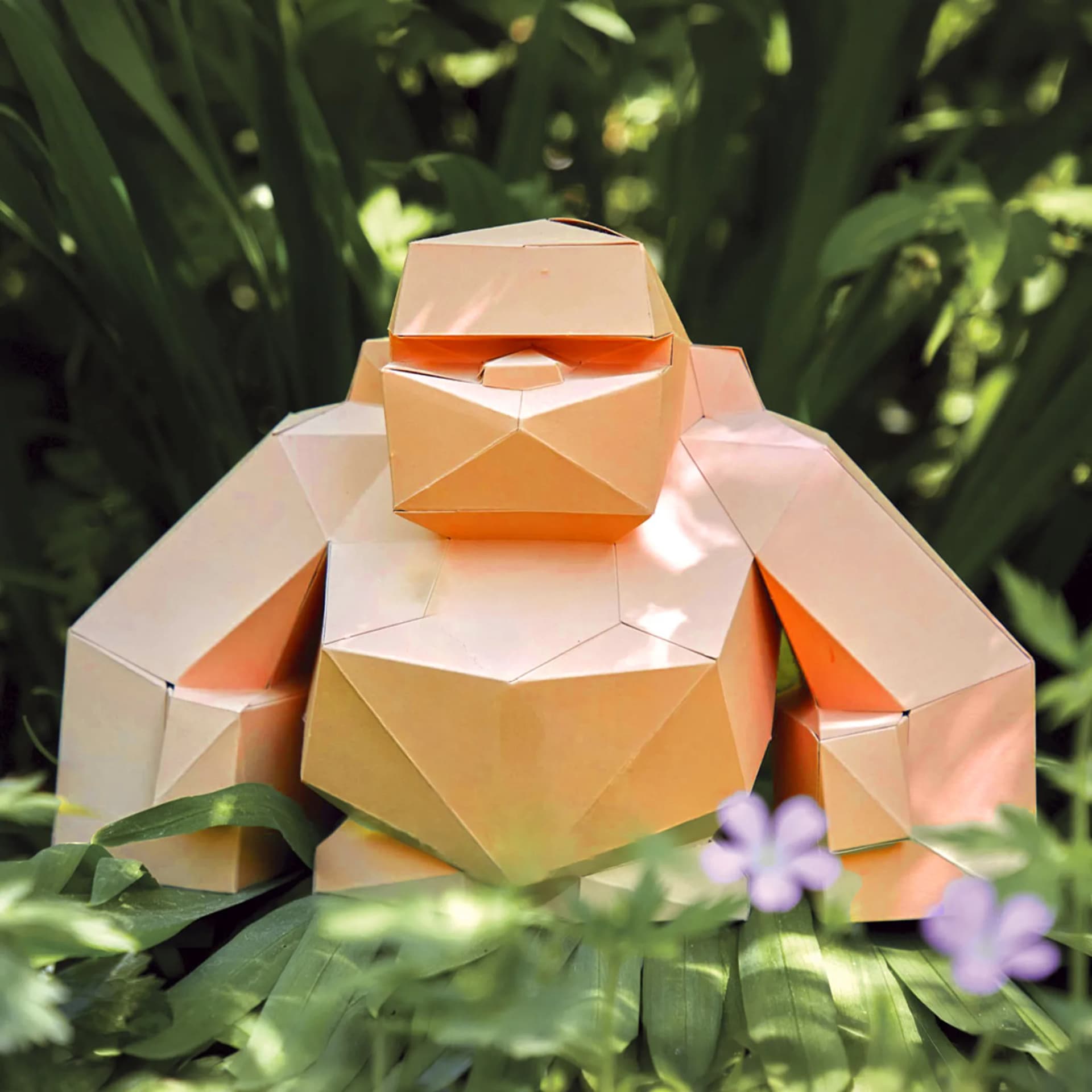 Décoration origami Petit Gorille en papier ABRICOT posé au milieu de plantes