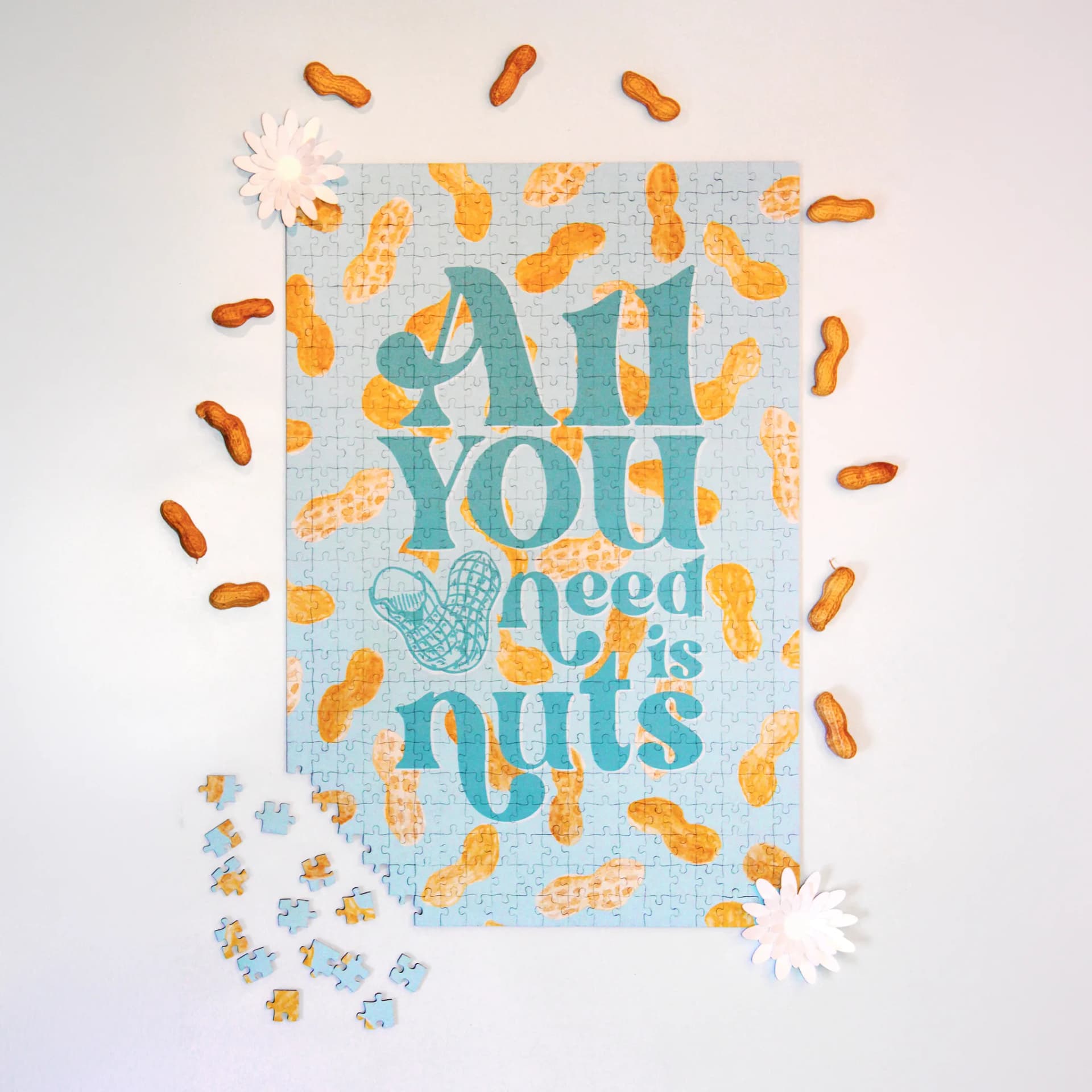 Puzzle - 500 pièces Arachide sur un fond bleu entouré de cacahouètes et de fleurs en papier