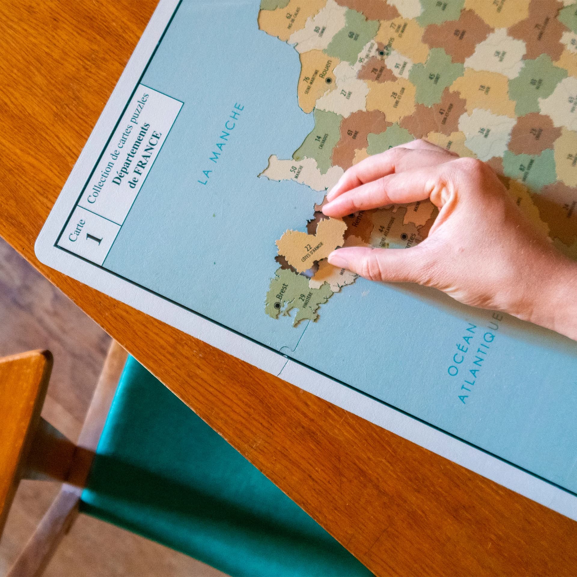 Puzzle Carte de France Vintage mis en situation avec une personne qui fait le puzzle
