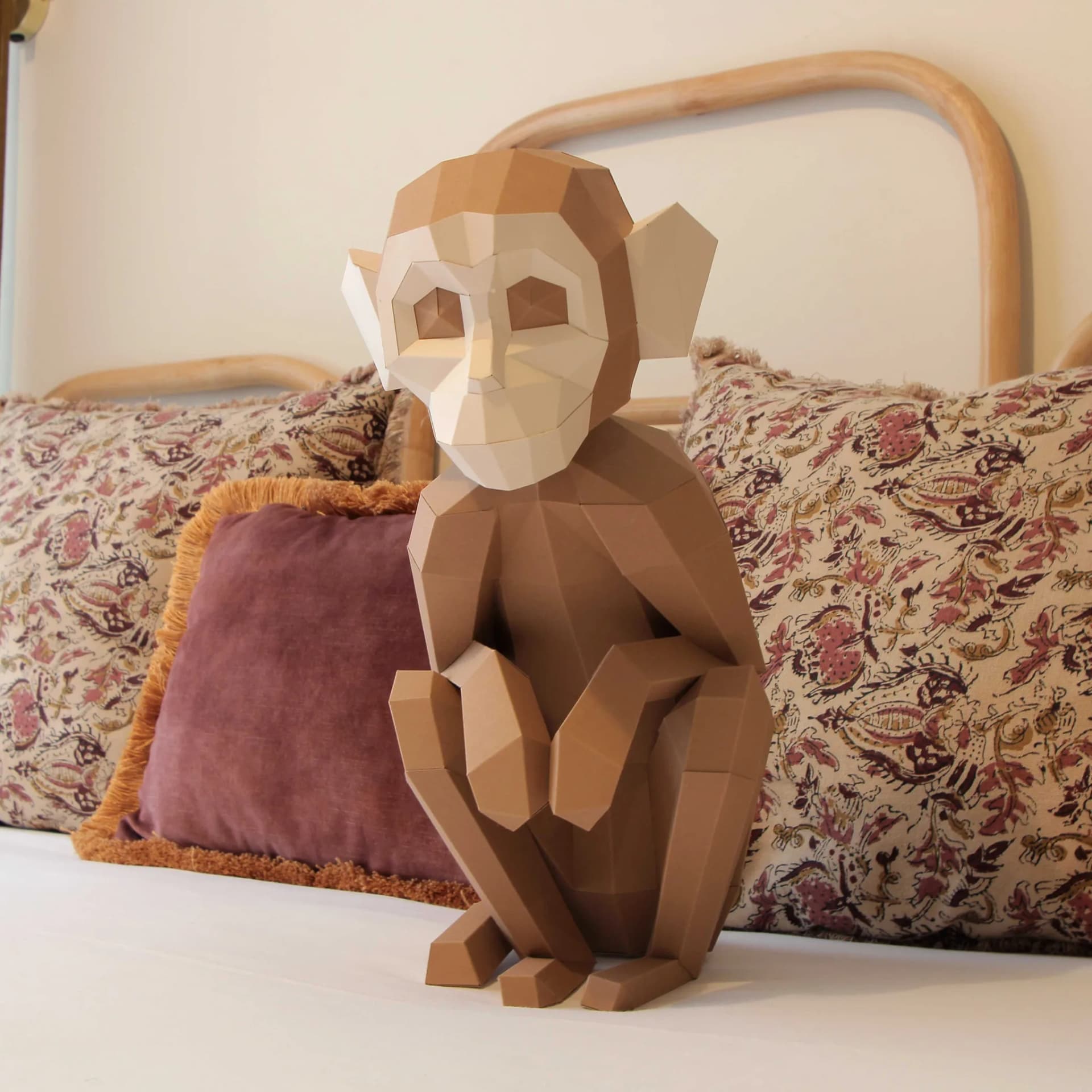 Décoration origami 3d singe assis marron sur la couverture blanche d'un lit