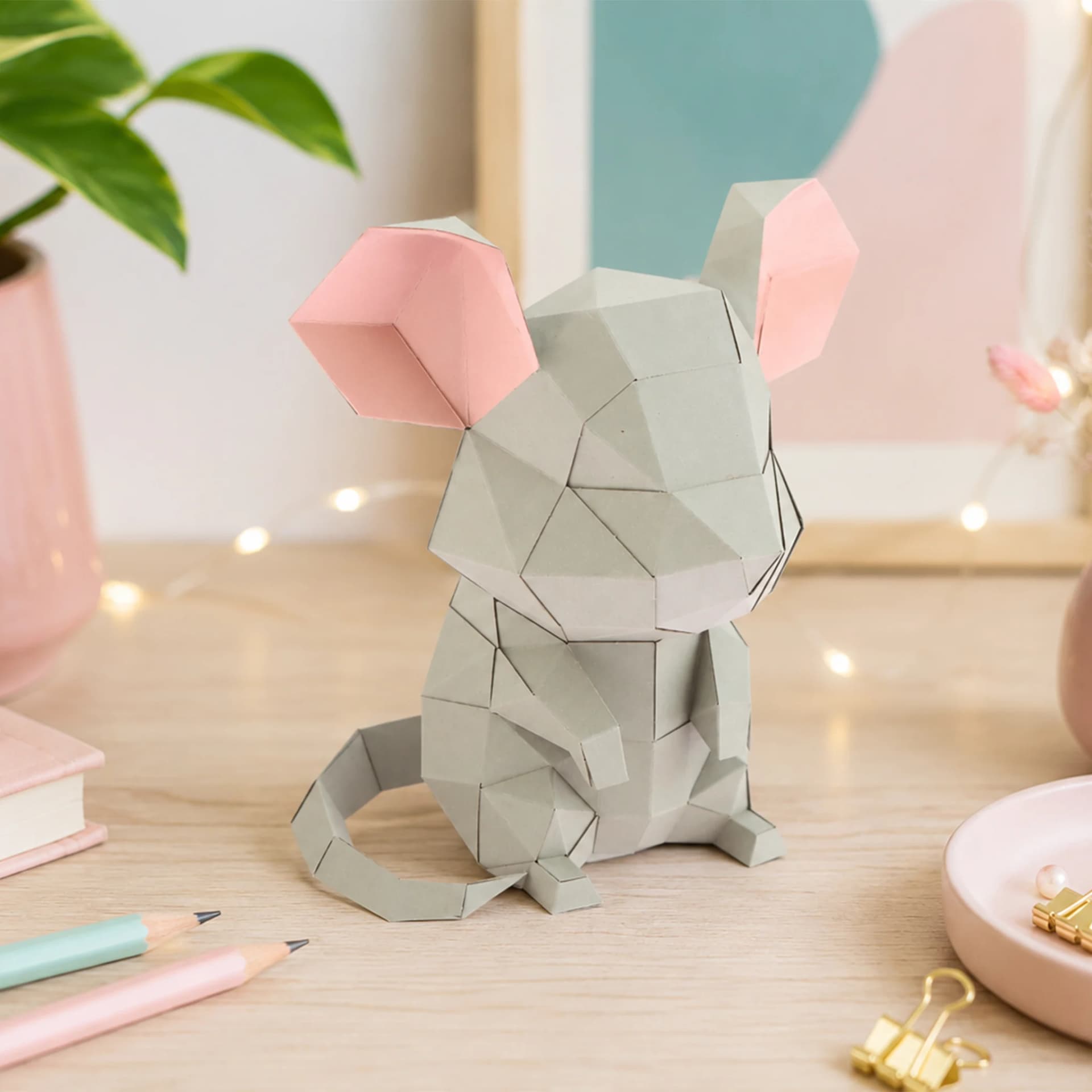 Décoration origami 3d souris grise, posée sur une coiffeuse blanche et rose à l'interieur d'une chambre