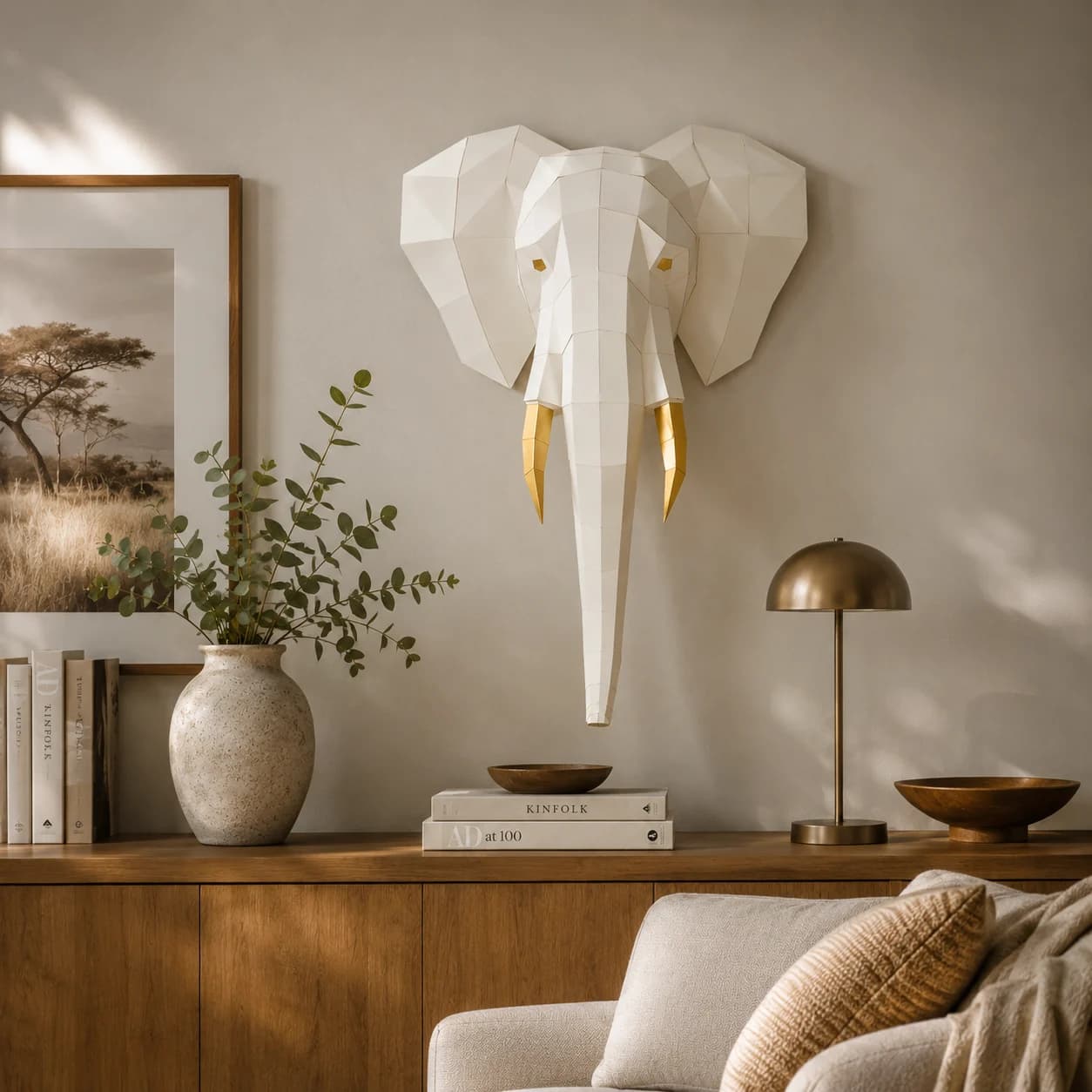 Décoration origami 3D en papier d'une tête d'éléphant crème accrochée au mur d'un salon dans l'esprit de la savane