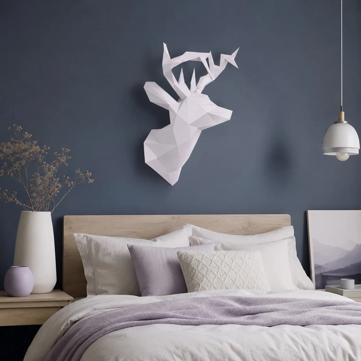 Décoration origami 3D en papier d'une tête de cerf blanche accrochée au mur au-dessus d'un lit dans une chambre