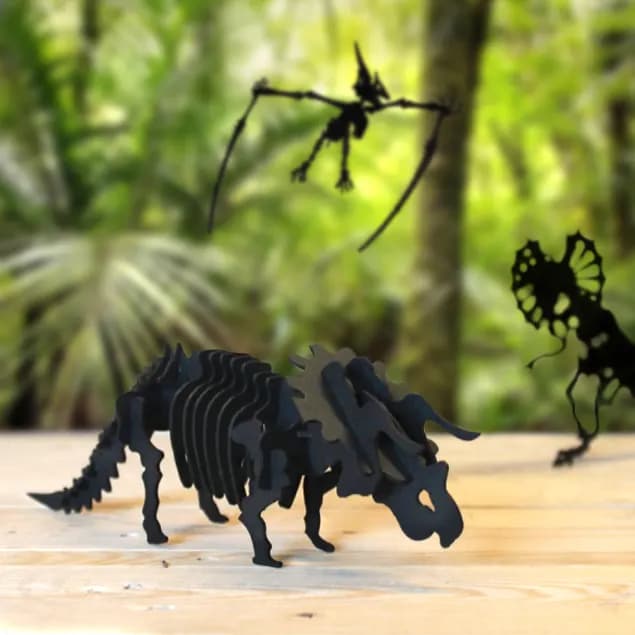 Décoration en carton d'un triceratops installé sur un bureau en bois