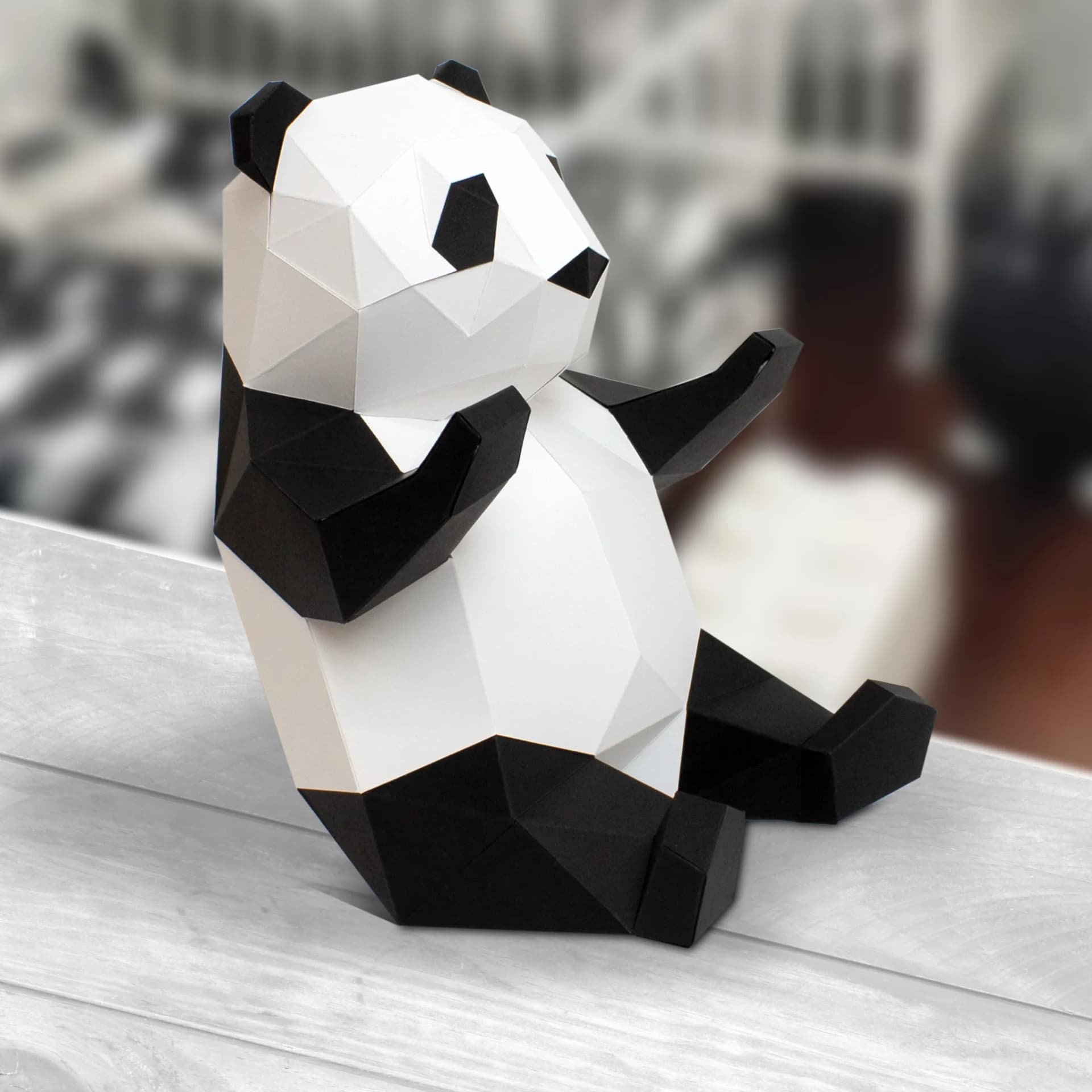Décoration en papier trophée babies panda noir et blanc posé sur une table en bois