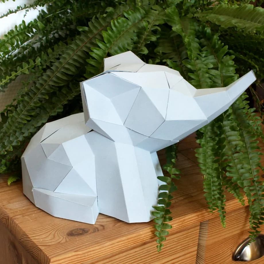 Décoration en papier trophée babies éléphant gris dans les herbes sur un meuble
