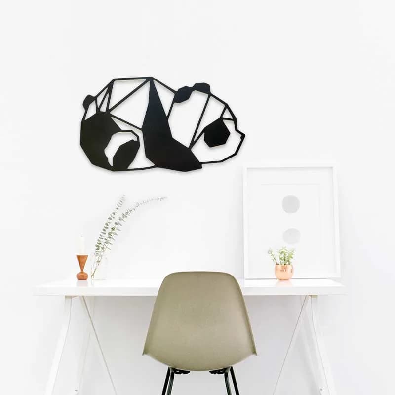 Trophée géométrique panda en carton noir et blanc installée au mur au dessus d'un petit bureau dans une chambre
